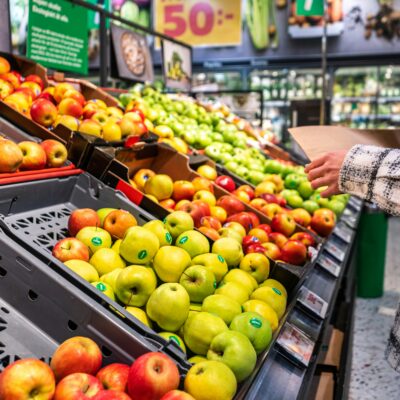 Picture of apples in a produce isle of a grocery store.